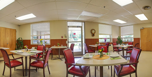 A cozy dining area with red chairs and neatly set tables, inviting for a meal.
