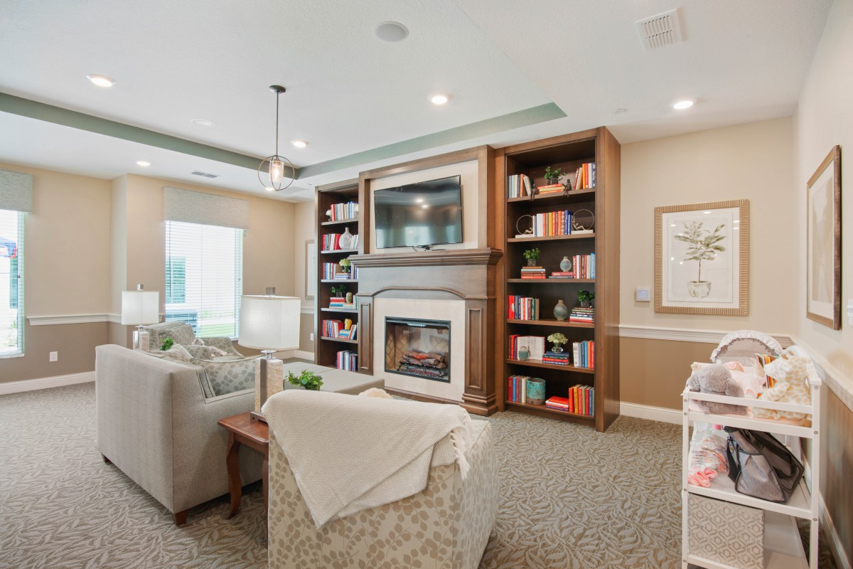 A cozy living room featuring a fireplace, bookshelves, and comfortable seating.