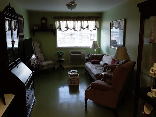 A cozy living room featuring soft green walls and comfortable seating.