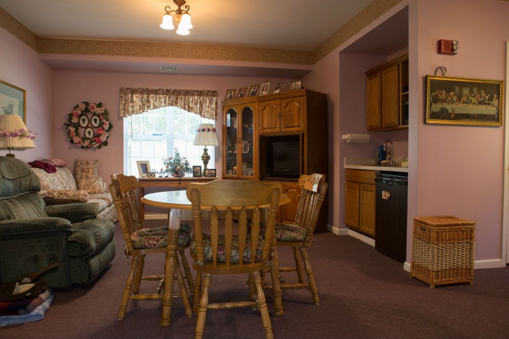 A cozy dining area with wooden furniture and a kitchen in the background.