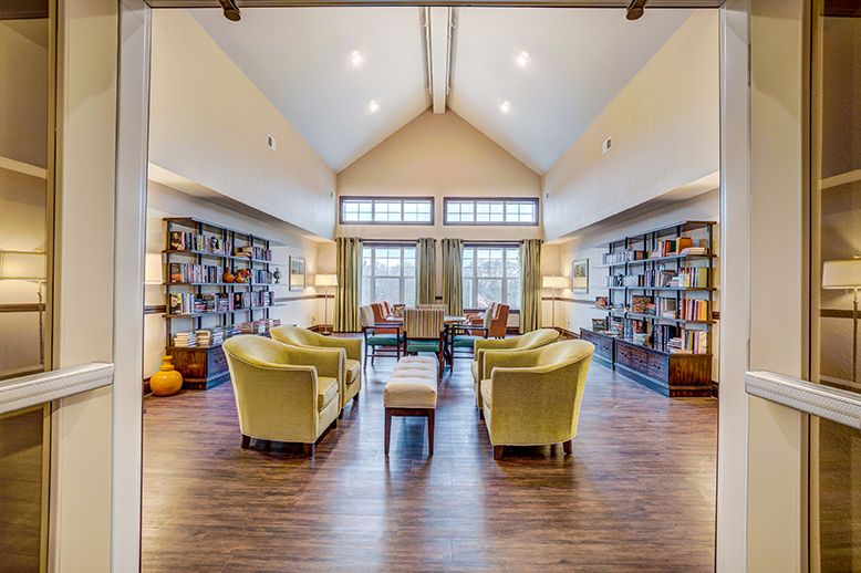 A cozy library reading room with bookshelves and comfortable seating.
