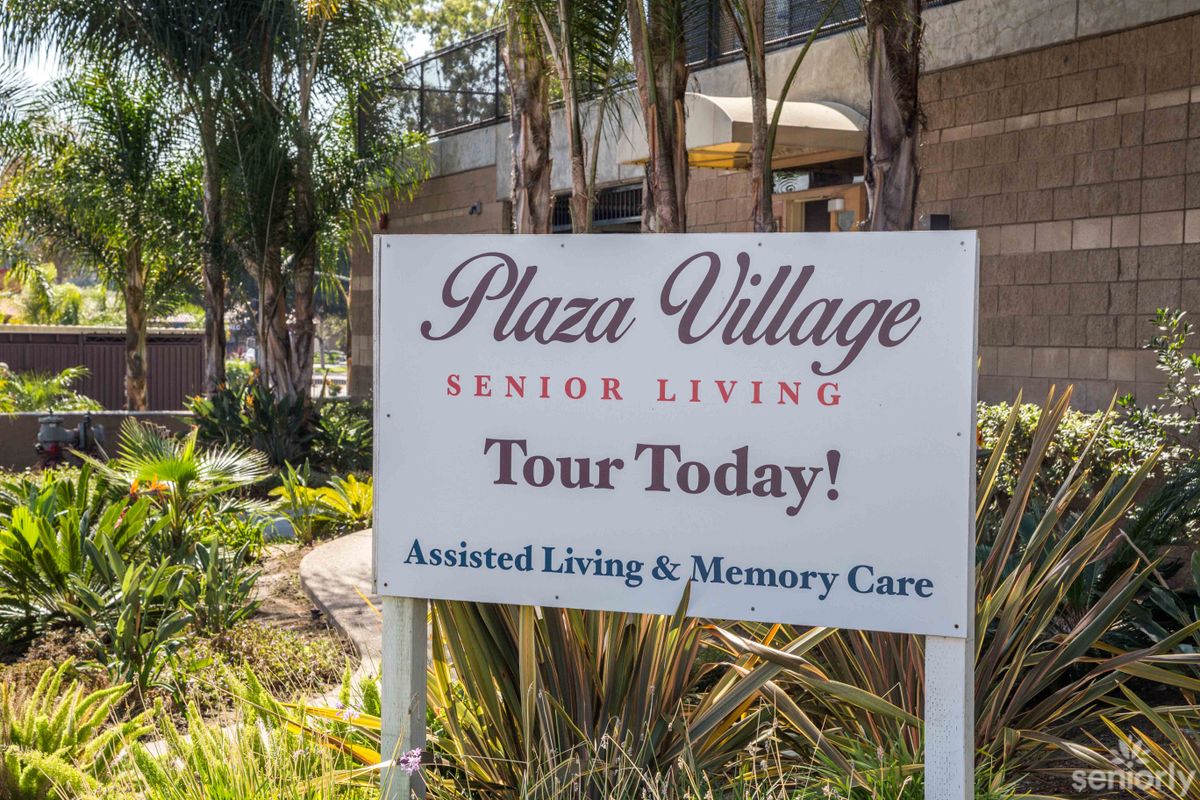 A sign for Plaza Village Senior Living, promoting tours and offering assisted living and memory care services.