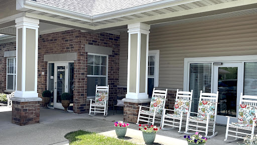 A serene outdoor porch featuring rocking chairs and potted flowers, perfect for relaxation.