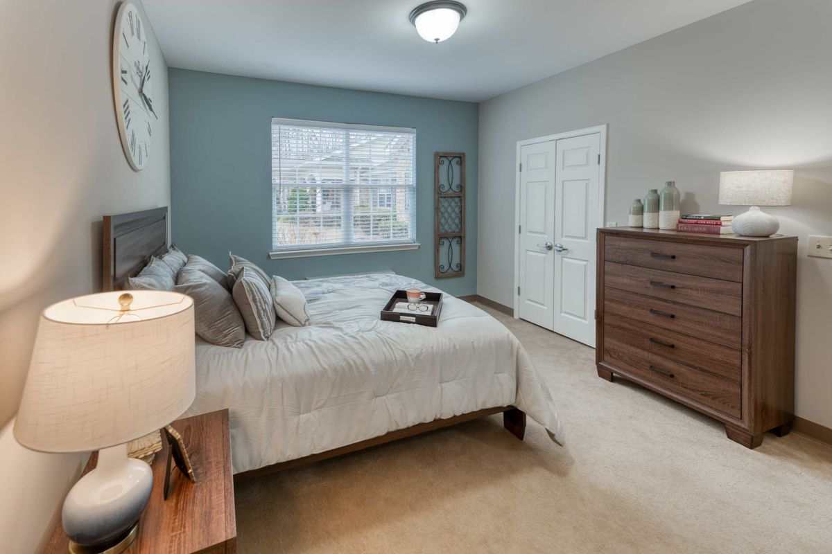 A cozy, well-decorated bedroom with a double bed, dresser, and soft lighting.