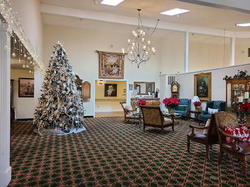 A cozy lobby decorated for the holiday season, featuring a beautifully adorned Christmas tree and elegant furnishings.