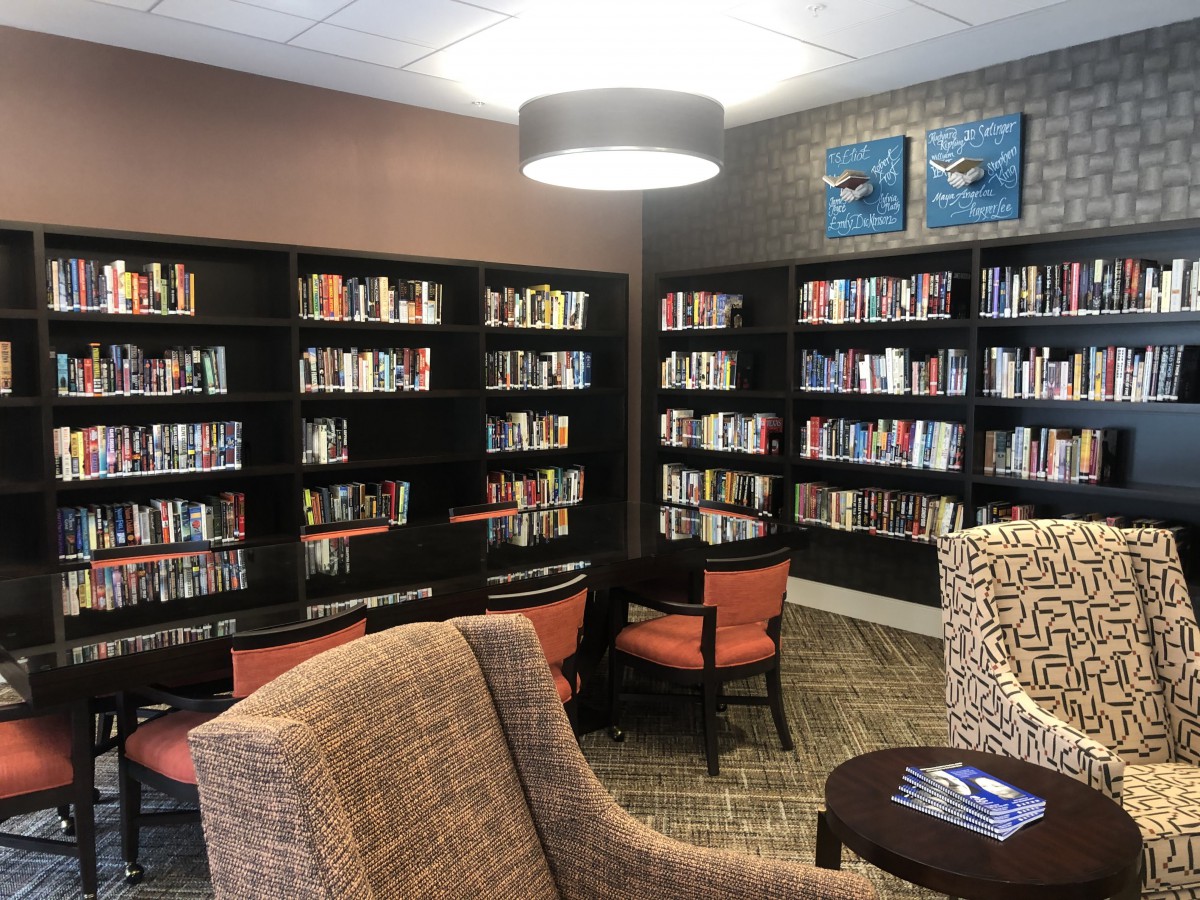 A cozy reading nook with bookshelves and comfortable seating in a library.