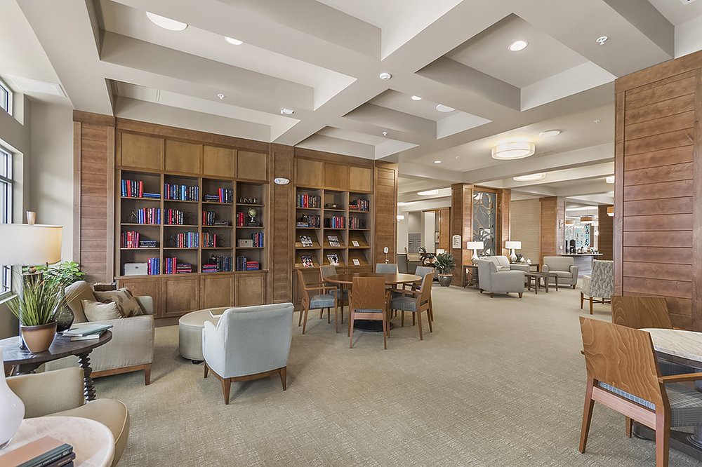 A modern library with comfortable seating and extensive bookshelves.