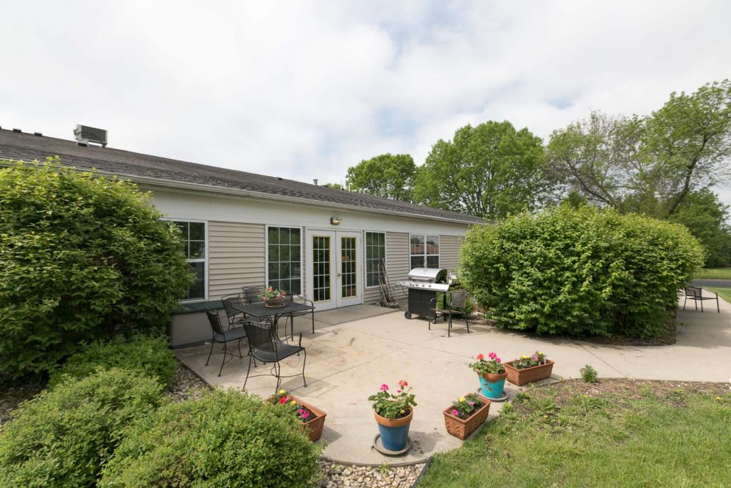 A peaceful backyard patio with outdoor furniture and lush greenery.