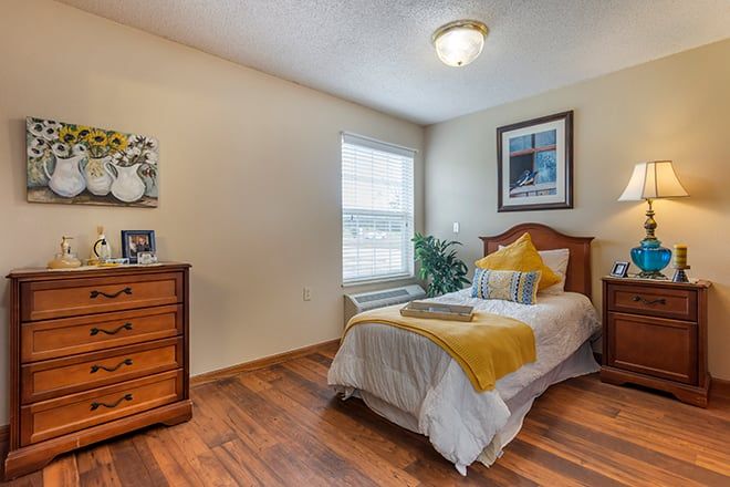 A cozy bedroom with a single bed, wooden flooring, and tasteful decor.