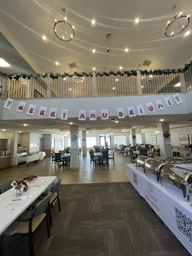 A spacious dining area beautifully decorated for a holiday celebration, featuring a buffet setup and festive banners.