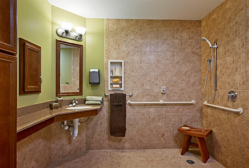 A spacious and accessible bathroom featuring modern fixtures and a comfortable seating area.