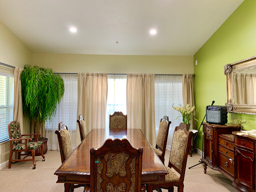A spacious dining room with elegant wooden furniture and green walls.