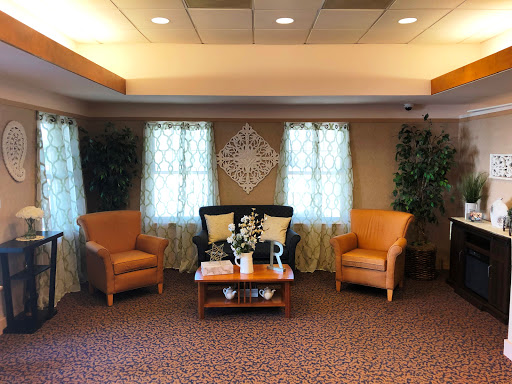 A cozy waiting area featuring comfortable armchairs, a coffee table, and natural light streaming through the curtains.