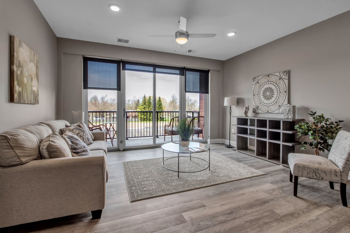 A modern living room with large patio doors, allowing natural light to illuminate the space decorated with contemporary furniture and neutral tones.