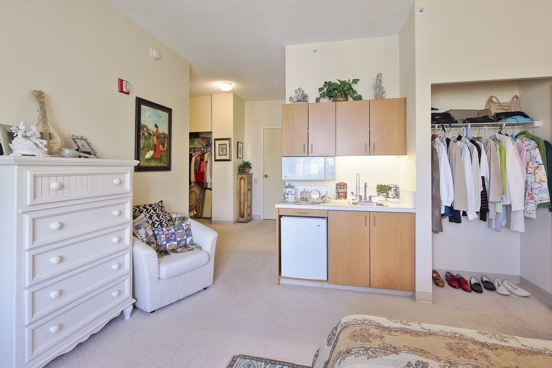 A cozy studio apartment with a kitchenette and neatly arranged furniture.