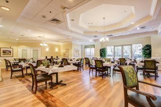 Elegant dining room with well-arranged tables and chairs, featuring warm lighting and a cozy atmosphere.