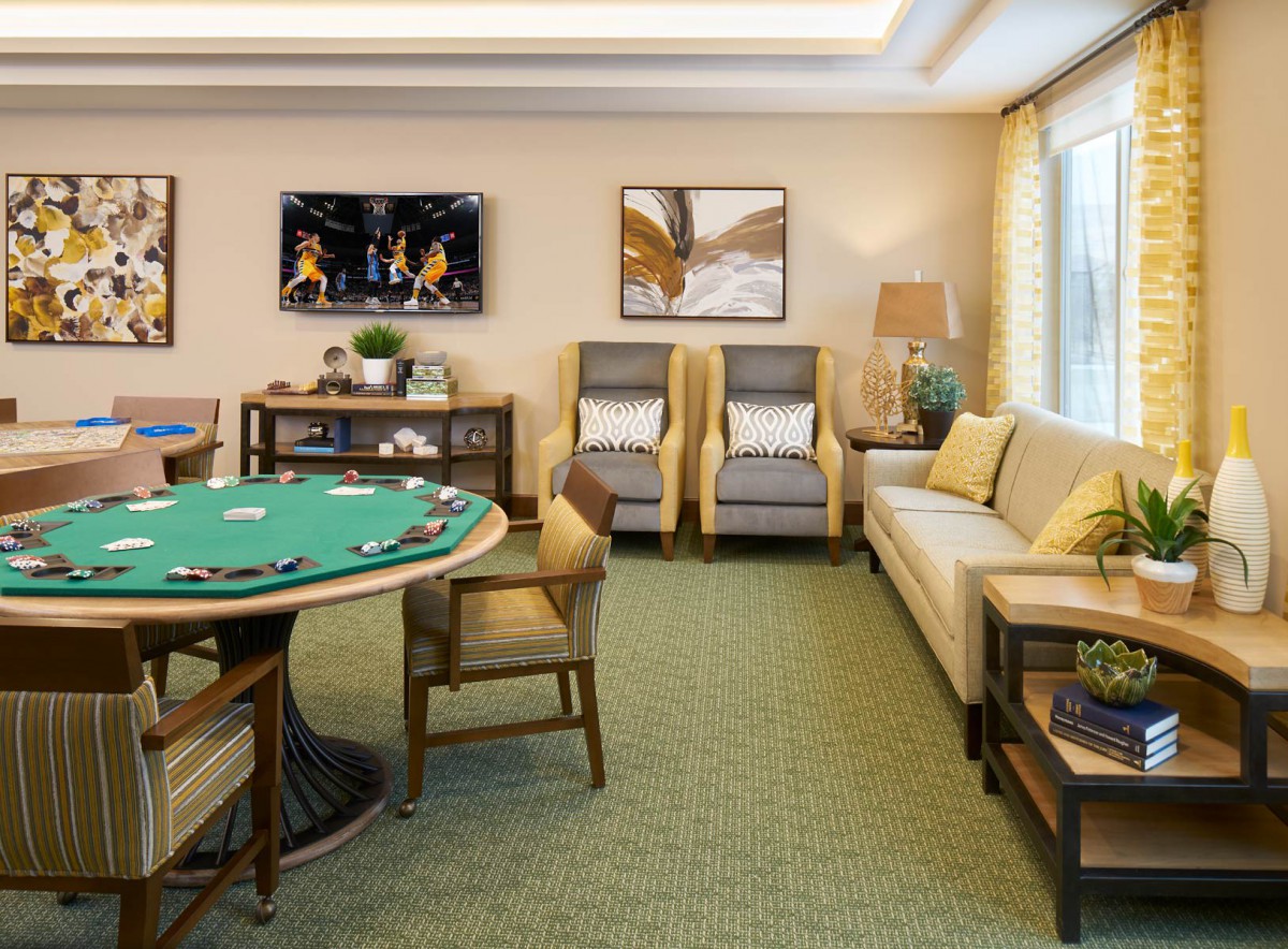 A cozy game room featuring a poker table, comfortable seating, a TV, and stylish decor.