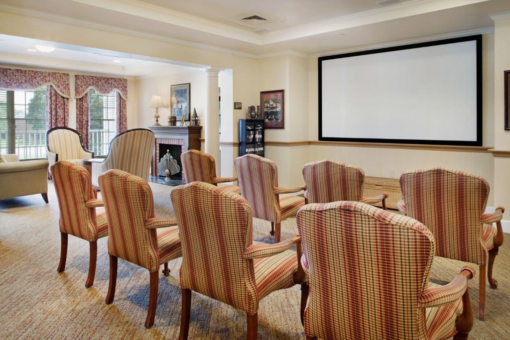 A conference room with arranged seating facing a large screen.