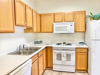 A modern kitchen with wooden cabinets, a microwave, stove, and sink.