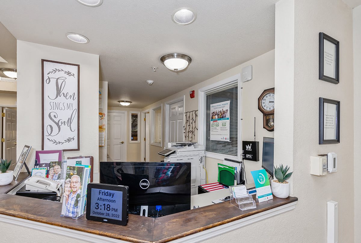 A tidy reception area featuring a computer, decorative items, and informational materials.