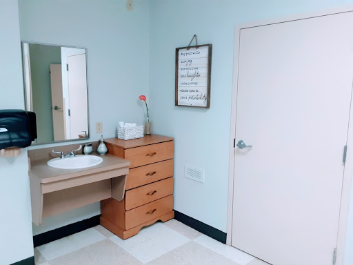 A clean and modern bathroom featuring a sink, mirror, and wooden storage unit.