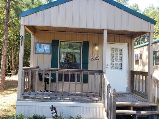 A quaint small house with a wooden porch and decorative elements.