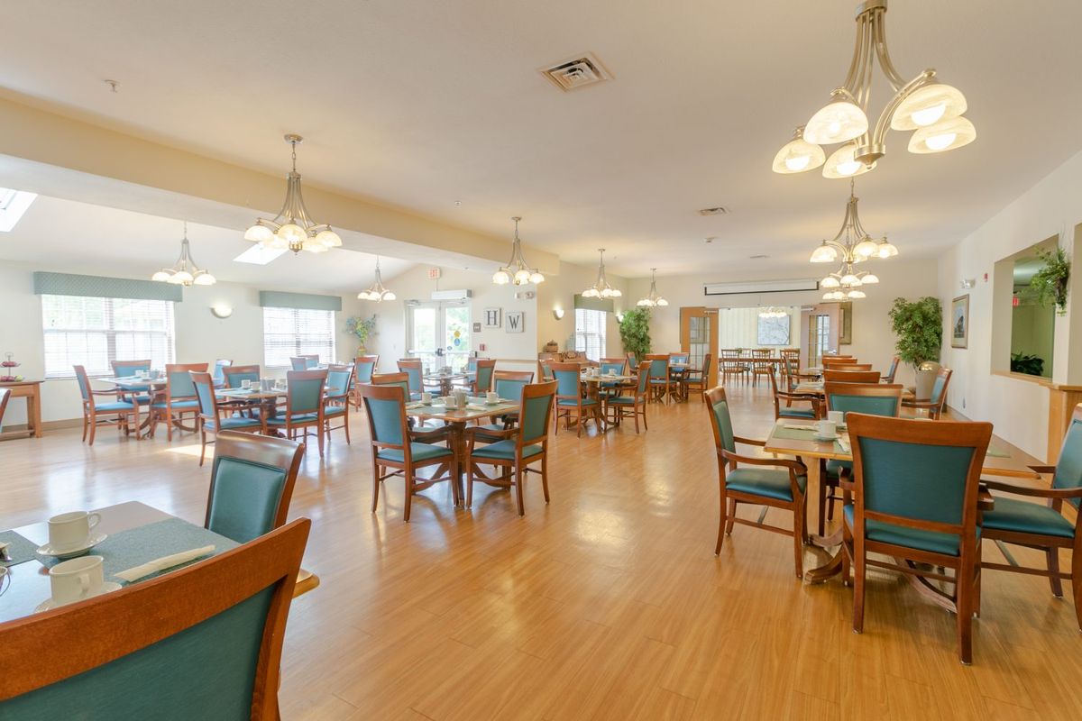 A spacious and well-lit dining room with neatly arranged tables and chairs.