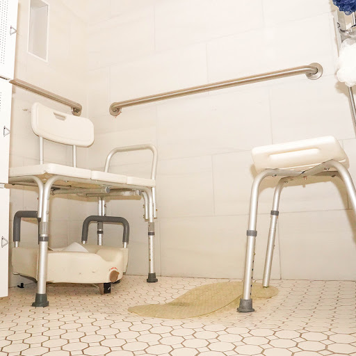 A bathroom designed for accessibility, featuring shower chairs and grab bars for safety.
