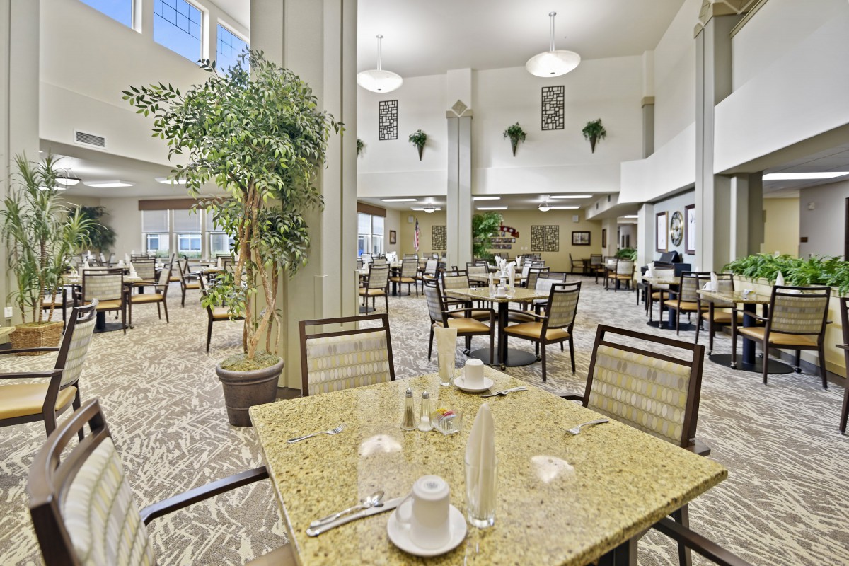 A spacious and well-lit dining area with neatly arranged tables and chairs.