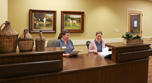 Two employees working at a reception desk in an office setting.