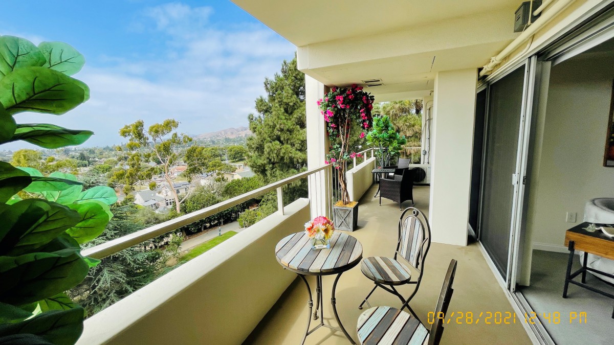 A cozy balcony with a table and chairs, offering a scenic view.