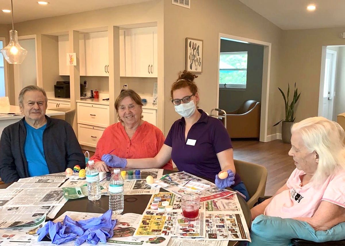 A group of people engaged in a crafting activity at a table indoors.