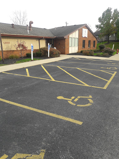 A view of a brick building with a designated handicapped parking spot in the lot.
