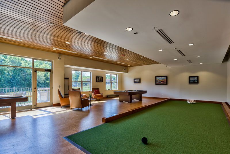 A spacious game room with a pool table, comfortable seating, and ample natural light.