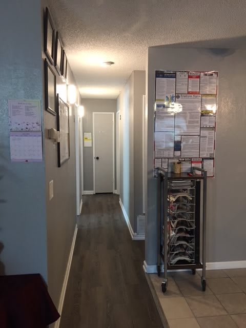 A home hallway with framed pictures and wooden flooring.