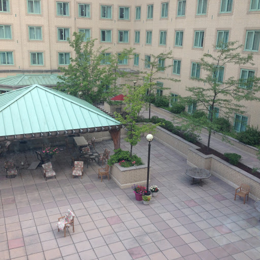 A serene outdoor space featuring a gazebo, seating arrangements, and greenery.