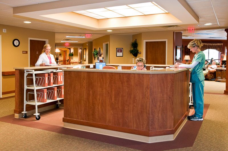 A nursing station in a medical facility with staff working at the reception desk.