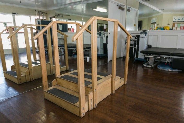 Wooden rehabilitation stairs in a physical therapy setting.