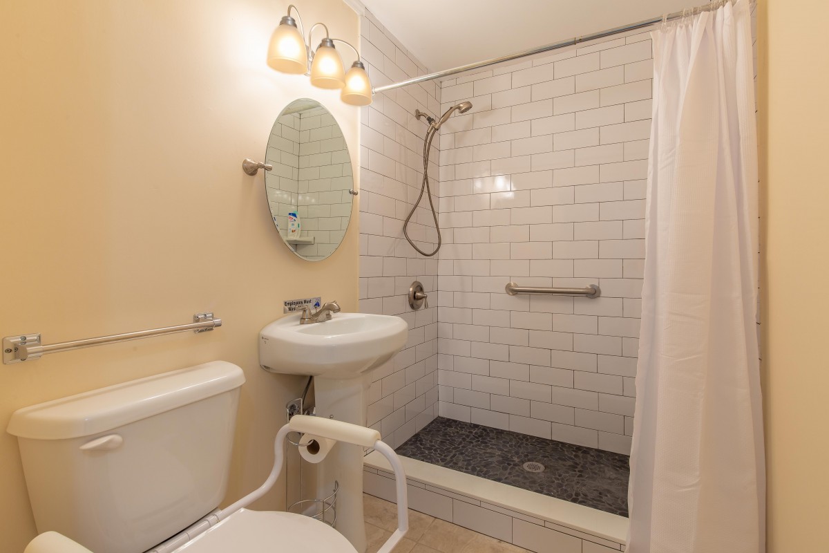 A modern bathroom with a shower area, sink, and toilet.