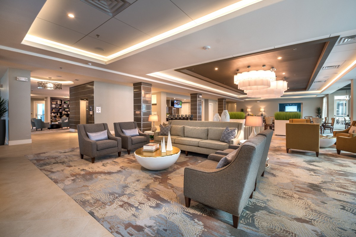 A modern and elegantly designed lobby with comfortable seating and a large chandelier.