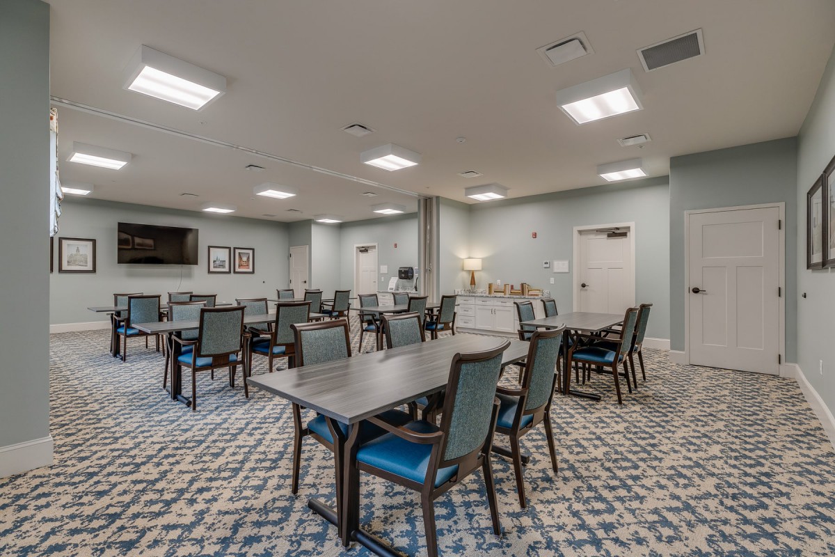 A spacious conference room with multiple tables and chairs arranged for a meeting.
