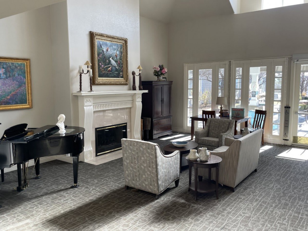 A stylish living room with a comfortable seating area and a fireplace, enhanced by natural light.