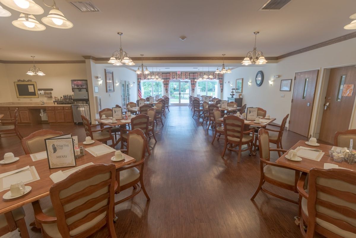 An empty dining room with neatly set tables and wooden chairs.