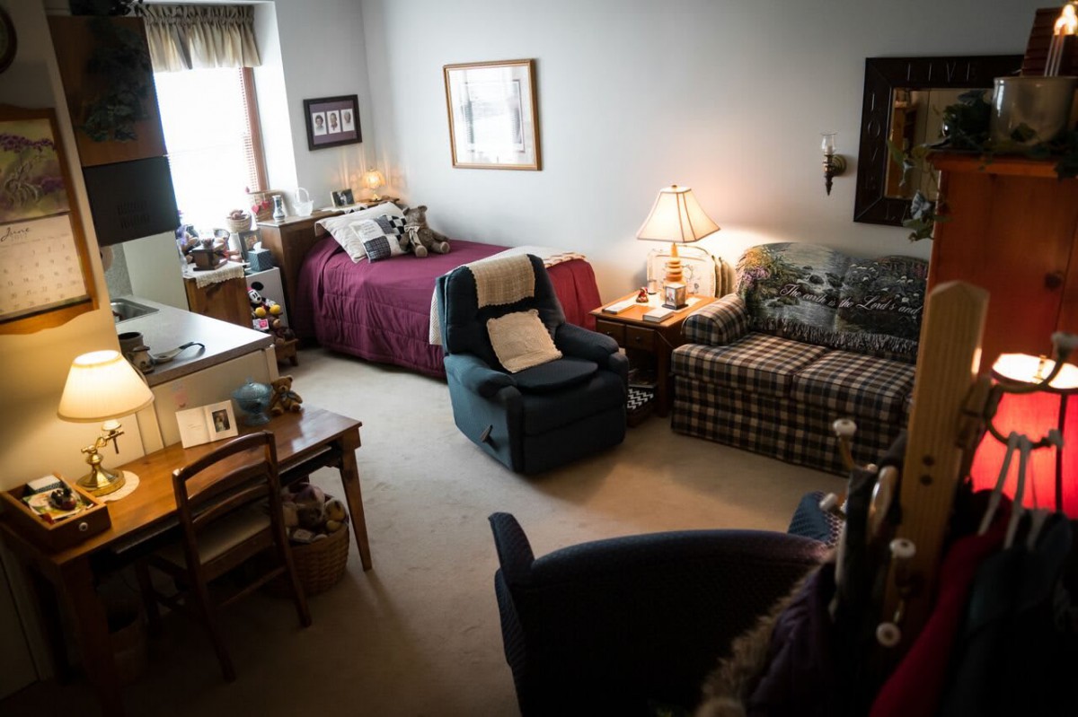 A cozy living room with a bed, sofa, and various furnishings.