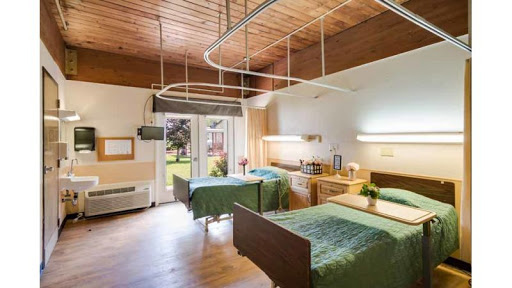 A spacious and well-lit hospital room designed for patient comfort.
