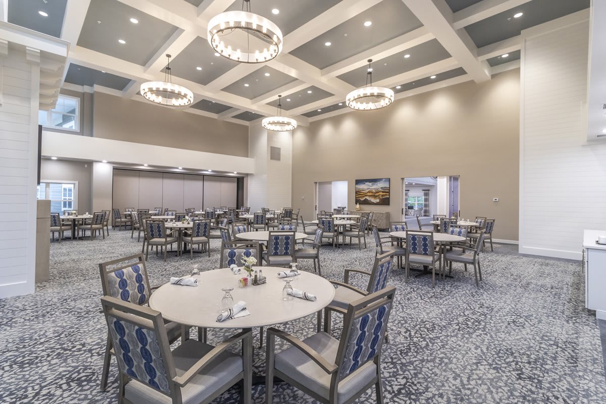An elegantly designed banquet hall with round tables and chandeliers, ready for an event.