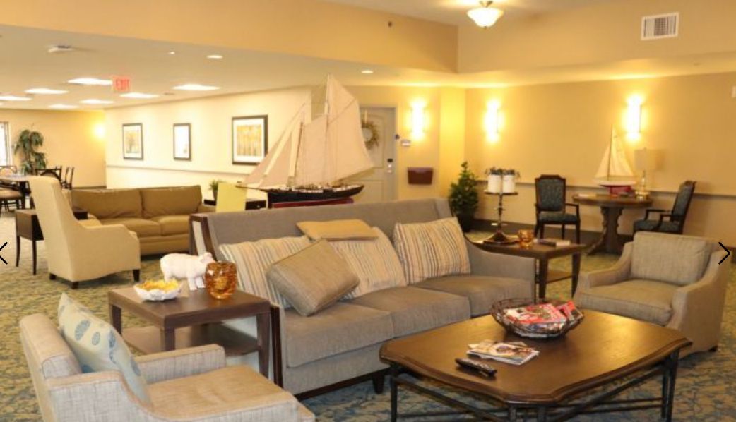 A cozy living room with a sofa, coffee table, and decorative model ship.