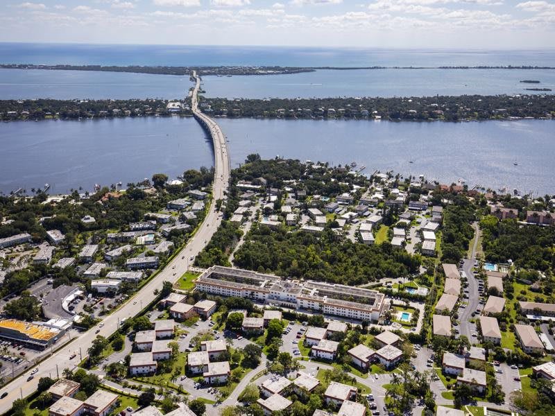 Aerial view of a bridge connecting to a residential area surrounded by water.