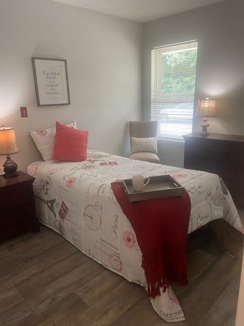 A cozy bedroom with a single bed, decorative pillows, and ambient lighting.