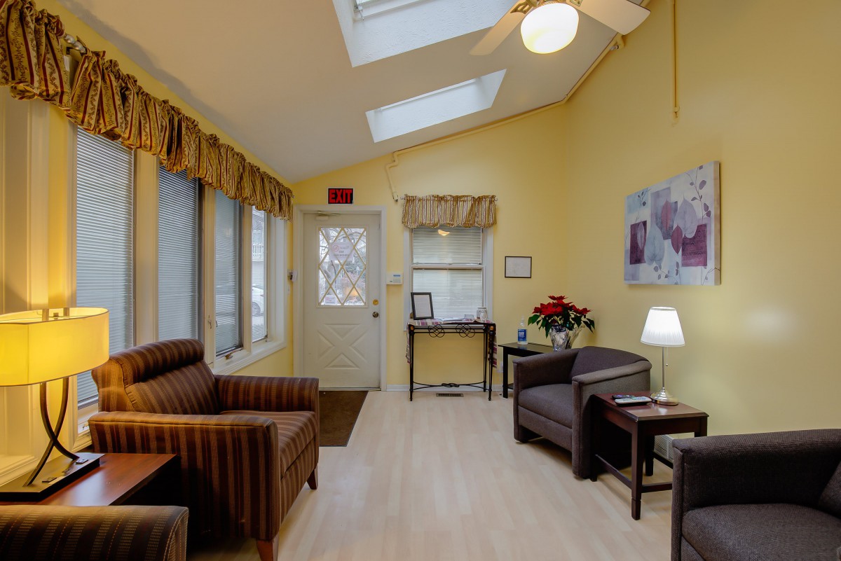 A well-lit living room with comfortable seating and skylights.